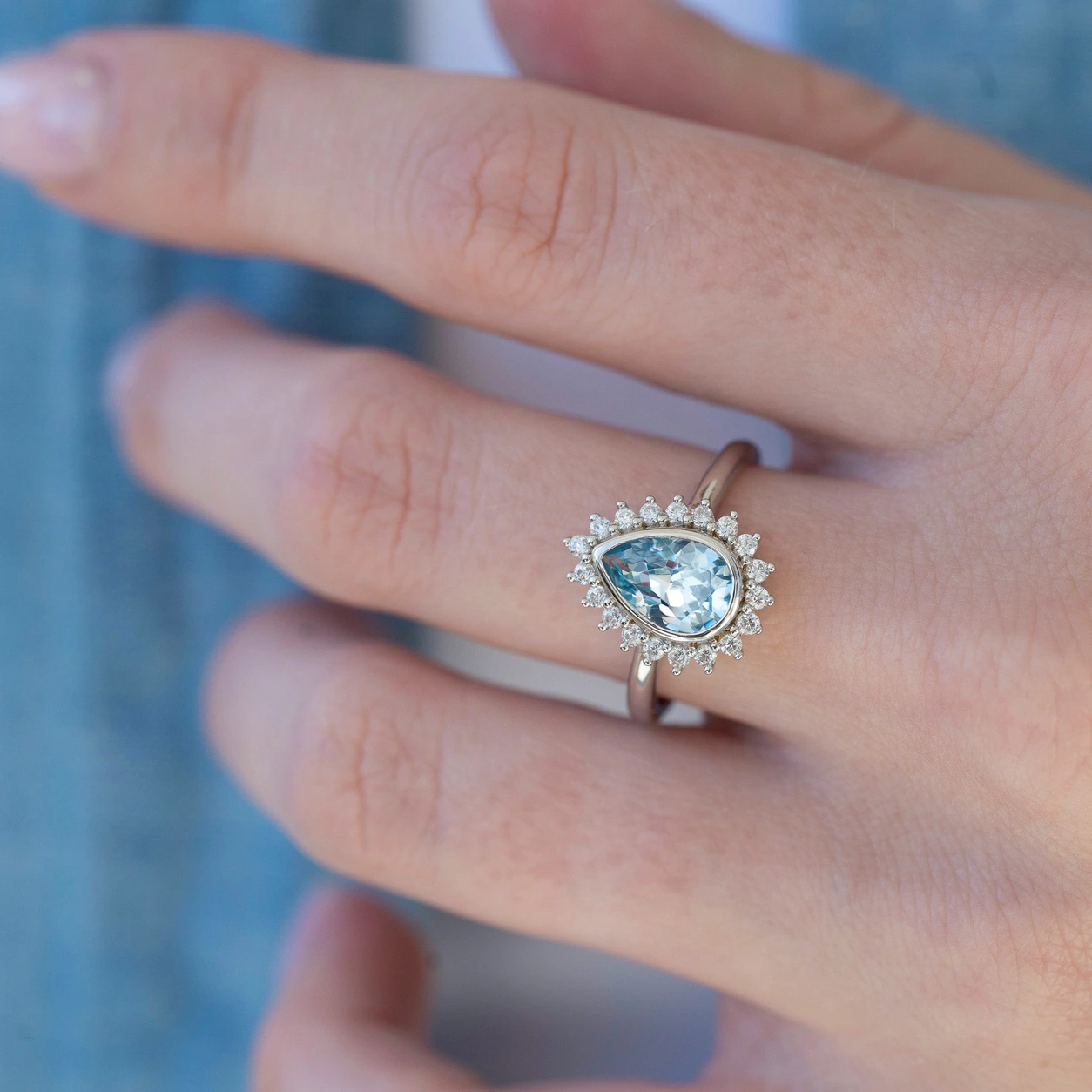 Teardrop aquamarine bezel ring shown on hand
